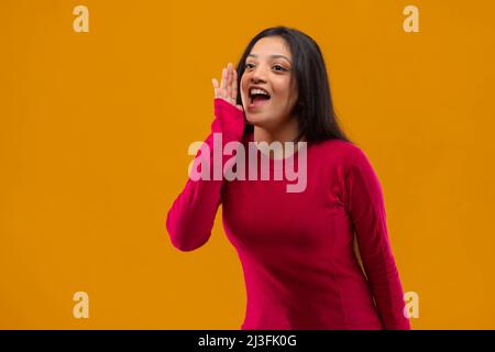 Giovane donna che grida e chiama qualcuno lontano Foto Stock