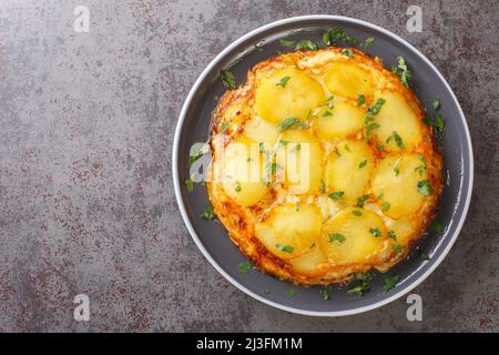 Pan haggerty è un piatto semplice, con piano cottura composto da patate, cipolla e formaggio a spicchio nel piatto sul tavolo. Vista dall'alto orizzontale da abov Foto Stock