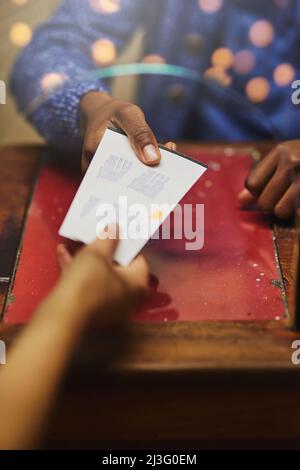 Biglietti per due, per favore. Scatto di una persona irriconoscibile che riceve i biglietti da un fornitore. Foto Stock