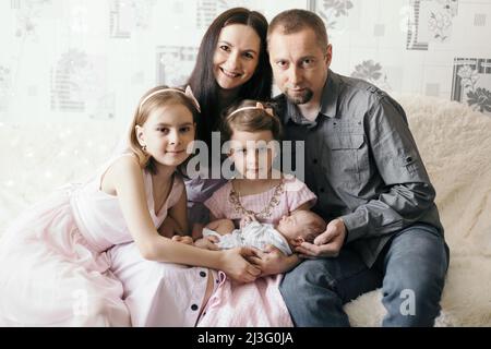 ritratto delle sorelle più anziane che abbraccia il loro fratello neonato . Foto Stock