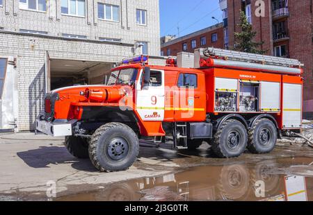 Samara, Russia - 07 aprile 2022: Camion dei pompieri rossi parcheggiato vicino alla stazione dei pompieri in giornata di sole Foto Stock