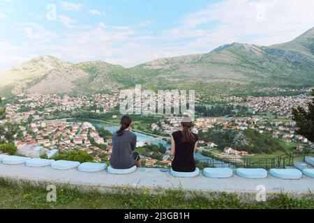 Vista posteriore due giovani ragazze seduti di fronte a grande paesaggio, Bosnia-Erzegovina Foto Stock