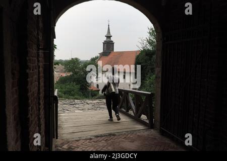 La donna attraversa la porta e il ponte nella Fortezza di Petrovaradin, Serbia Foto Stock