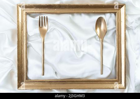 poster del ristorante, menu, mockup di lusso biglietto da visita. Concetto creativo di ambiente da pranzo con cornice dorata, cucchiaio e forchetta Foto Stock