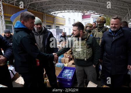 Il presidente ucraino Volodymyr Zelenskyyyyyha visitato la città di Bucha nella regione di Kyiv, dove si sono svolte uccisioni di massa di civili durante l'occupazione da parte delle truppe russe. Il capo di Stato ha visitato il centro di aiuto umanitario e ha parlato con i residenti locali. Il sindaco di Buca Anatoliy Fedoruk ha raccontato al presidente la situazione umanitaria nella città, i progressi della ricerca dei corpi dei morti, la valutazione dei danni causati dagli occupanti ai beni privati e comunali, e il ritmo di ricostruzione della città. Foto Stock