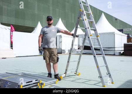 Francia, Tolosa, 2022-04-08. Ritratto di un uomo che lavora all'installazione. Installazione della Fiera Internazionale di Tolosa dal 9 al 18 aprile 2022 presso il MEETT, con l'etichetta "Foires de France". Primo evento economico della regione dell'Occitanie, avrà il doppio degli espositori rispetto al 2021. La ruota panoramica, l'Arena eSport che coprirà 1200 m², il Villaggio dello Sport, i nuovi settori Innovaa' Toulouse e Green Village. Tante attrazioni che punteggiano in questi dieci giorni. Photo by Patricia Huchot-Boissier/ABACAPRESS.COM Credit: Abaca Press/Alamy Live News Foto Stock