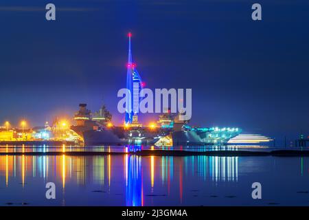 Una vista notturna dei vettori aerei Royal Navy HMS Queen Elizabeth e HMS Prince of Wales insieme accanto alla base navale nel porto di Portsmouth. Foto Stock