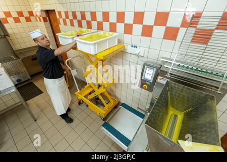 Francia, Mosa, Commercy, Stéphane Zins prepararsi a versare l'impasto madeleine nella macchina automatica di tappatura nel negozio e laboratorio di produzione madeleine di Commercy la Boite à madeleine dei fratelli Zins, madeleiniers dal 1951 Foto Stock