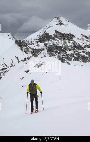 Francia, Ariège, massiccio dei Pirenei, Vicdessos, Val de Sos, Escursione con racchette da neve al Pic des Trois Seigneurs, un escursionista sulla cresta del Pic de Barrès e la cima del Pic des Trois Seigneurs Foto Stock