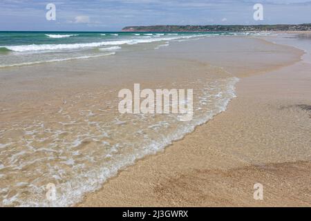 Francia, Manica, Cotentin, Sciotot Cove, tra Les Pieux e le Rozel, spiaggia di sabbia fine dorata, ondulazioni di acqua trasparente e Capo Flamanville sullo sfondo Foto Stock