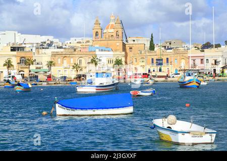 Malta, Marsaxlokk, porto di pesca fondato dai Fenici nel 9th a.C. JC con sullo sfondo la facciata della chiesa parrocchiale di nostra Signora di Pompei (1897) Foto Stock