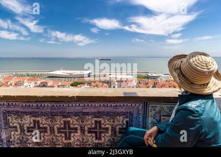 Portogallo, Lisbona, quartiere di Alfama, Miradouro de Santa Luzia, donna ammirando la vista sui tetti del quartiere vecchio Foto Stock