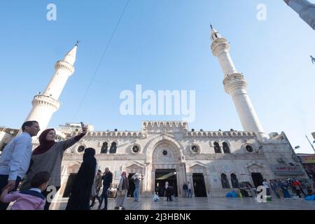 Una famiglia che prende selfie di fronte alla moschea di al-Husseini nella capitale della Giordania in una giornata di sole. Amman, Giordania Foto Stock