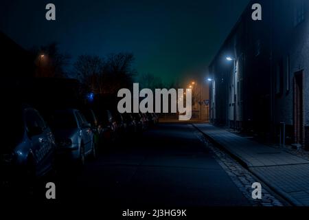 Germania, Luckenwalde, un po 'di nebbia di notte per le strade della città sotto i semafori Foto Stock