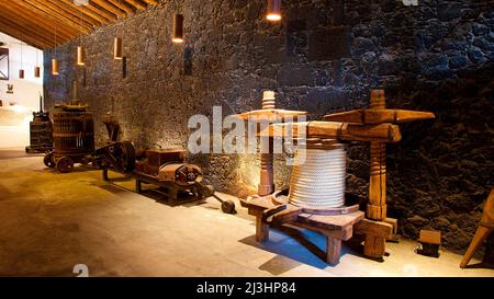 Isole Canarie, Lanzarote, isola vulcanica, zona viticola la Geria, a sud del Parco Nazionale di Timanfaya, Bodega la Geria, museo del vino, interni, pressa dell'uva in legno e altre attrezzature, luce artificiale Foto Stock