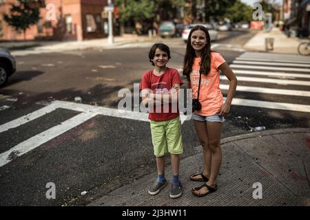 Myrtle Av/Broadway, New York City, NY, USA, adolescente caucasico di 14 anni e adolescente caucasico di 12 anni, entrambi con capelli marroni e stile estivo in una traversata zebra a Brooklyn Foto Stock