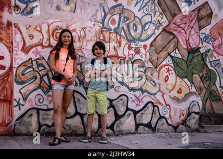 Lafayette Ave/Stuyvesant Av, New York City, NY, USA, adolescente caucasico di 14 anni e adolescente caucasico di 12 anni, entrambi con capelli marroni e stile estivo di fronte a un Graffiti a Brooklyn Foto Stock