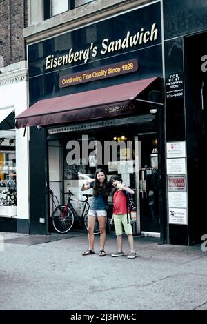 23 Street, New York City, NY, USA, 14 anni adolescente caucasico e 12 anni adolescente caucasico - entrambi con capelli marroni e stile estivo di fronte al Sandwich Shop di Eisenberg - un famoso paninoteca classico di New York. E 'aperto dal 1929 nel distretto di Flatiron. Foto Stock