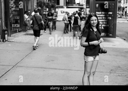 5 Avenue & West 26 STREET, New York City, NY, USA, 14 anni ragazza caucasica adolescente che indossa una macchina fotografica per le strade di NYC Foto Stock