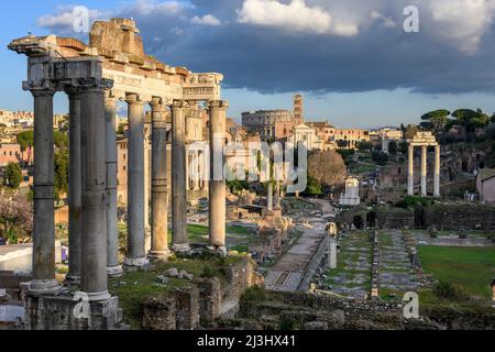 Guardando attraverso il Foro Romano dal Campidoglio, con il tempio di saturno in primo piano e il Colosseo in lontananza, Roma, Italia. Foto Stock