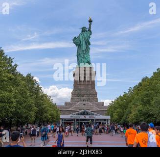 Liberty Island, New York, NEW York, USA, una vista inaspettata della famosissima Statua della libertà a New York. Catturato contro un cielo drammatico. Foto Stock