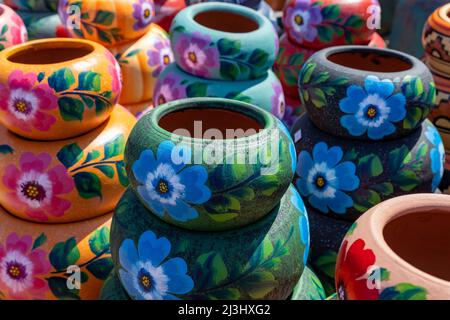 Varietà di pod in ceramica dipinta in stile messicano in un mercato di souvenir all'aperto per lo shopping in Messico. Foto Stock