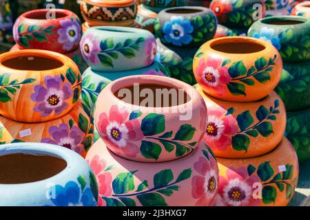 Varietà di pod in ceramica dipinta in stile messicano in un mercato di souvenir all'aperto per lo shopping in Messico. Foto Stock