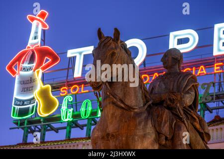 Il famoso cartello pubblicitario Tio Pepe si erge su una statua di re Carlo III, nella Puerta del Sol, nel centro di Madrid, Spagna. Foto Stock