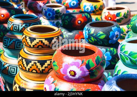 Varietà di pod in ceramica dipinta in stile messicano in un mercato di souvenir all'aperto per lo shopping in Messico. Foto Stock