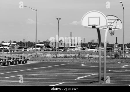 JACOB RIIS PARK ROAD/BATH HOUSE, New York City, NY, USA, campo da pallacanestro con skyline di nyc sullo sfondo Foto Stock