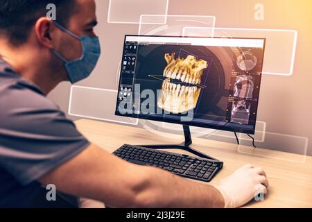 Dentista attento esame di un x-ray sul computer in clinica dentale Foto Stock