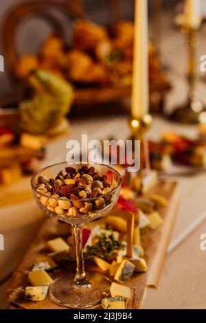 Assortimento di dadi in ciotole. Anacardi, nocciole, noci, pistacchi, noci pecan, pinoli, arachidi, macadamia, mandorle, noci brasiliane. Mix di cibo su legno Foto Stock