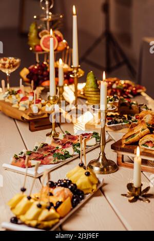 tavolo festivo con candele per feste di nozze al buio. Foto Stock