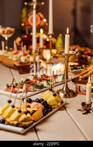 cibo servito al tavolo festivo, piatti di frutta, formaggio, tartine e affettati per il buffet. Catering Foto Stock