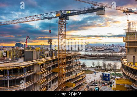 Vienna, tramonto ardente in cantiere di casa di appartamenti di alto livello, fiume Donau (Danubio), ruota panoramica, centro di Vienna, gru, Cantiere, progetto 'Danube Flats' nel distretto 22. Donaustadt, Austria Foto Stock