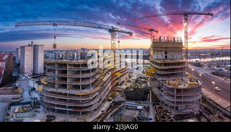 Vienna, tramonto ardente nel cantiere di casa di appartamenti di alto livello, fiume Neue Donau (nuovo Danubio, fronte), Donau (Danubio), isola Donauinsel, ruota panoramica, Vienna centro città, gru, cantiere, progetto 'Danube Flats', Donaucity nel distretto 00., panoramica, Austria Foto Stock