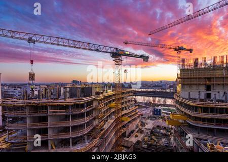 Vienna, tramonto ardente nel cantiere di casa di appartamenti di alto livello, fiume Neue Donau (nuovo Danubio, fronte), Donau (Danubio), isola Donauinsel, ruota panoramica, Vienna centro città, gru, cantiere, progetto 'Danube Flats', Donaucity nel distretto 00., panoramica, Austria Foto Stock