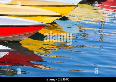 Barche colorate affiancate in uno dei canali d'acqua di Venezia, riflesse nell'acqua, Italia, Veneto Foto Stock