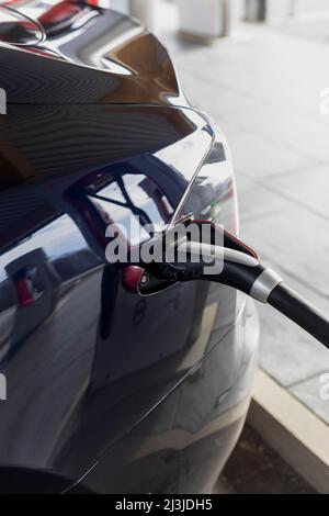 Dettaglio della spina di carica durante la ricarica di una Tesla in Germania Foto Stock