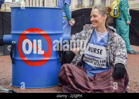 Londra, Regno Unito. 7th aprile 2022. Estinzione i medici della ribellione e gli operatori sanitari hanno bloccato la strada al di fuori del Tesoro HM a Westminster la Giornata Mondiale della Sanità, in protesta contro il finanziamento del governo di combustibili fossili. Diversi manifestanti si sono incollati a barili. Foto Stock