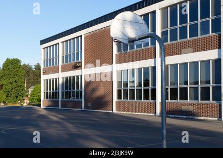 Esterno dell'edificio scolastico e cortile con parco giochi Foto Stock