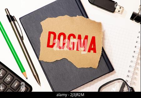 dogma di parola stampato su carta bianca macro. Foto Stock