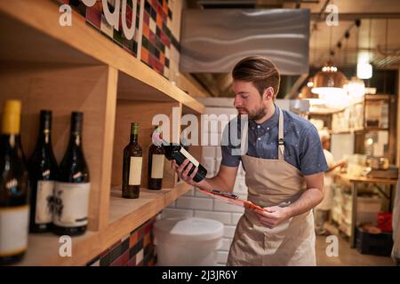 Sembra che abbia bisogno di più di questi. Shot di un giovane imprenditore contando la sua merce. Foto Stock