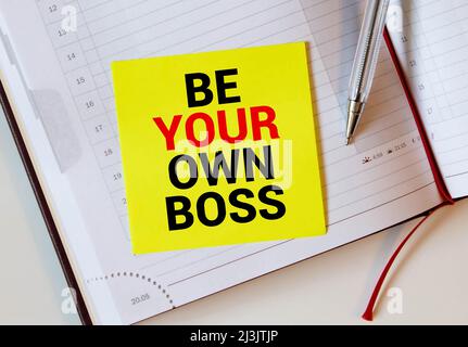 La frase essere il tuo Boss in rosso testo su una nota gialla appiccicosa come incentivo a prendere il controllo Foto Stock