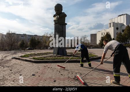 I lavoratori ripuliscono le macerie di fronte a una statua danneggiata del poeta ucraino Taras Shevchenko, e la sua poesia ha scritto "Love Your Ukraine, Love it during the Rage, all'ultimo momento difficile. Pregate per lei." In seguito alla riconquistazione di Borodyanka da parte delle forze ucraine, la città fu pesantemente devastata e trasformata in rovine sotto intensi combattimenti e bombardamenti. Come il presidente ucraino Volodymyr Zelensky ha avvertito che la situazione nella città di Borodyanka, a circa 15 miglia da Buca, era "significativamente più terribile". Foto Stock