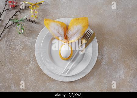 Bella Pasqua impostazione tavolo con piatti e tovagliolo coniglio di Pasqua, willow twig, vista dall'alto, spazio copia Foto Stock