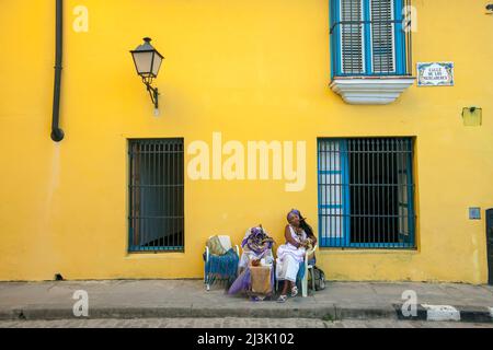 Un tessitore di fortuna e un lettore di carte tarocchi si siede lungo la strada nel centro di Havana, Cuba - Viejo e fuma un sigaro; Havana, Cuba Foto Stock