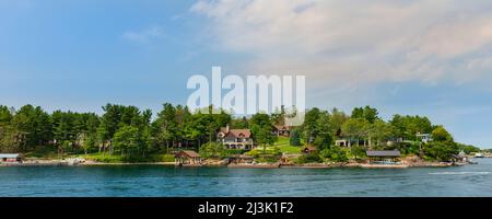 Case sul lungomare e attracchi lungo un litorale dell'isola nelle Thousand Islands, Ontario, Canada Foto Stock