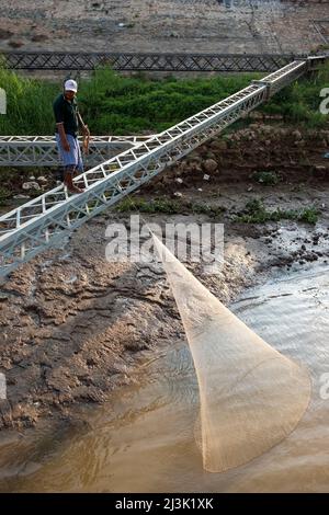 Un uomo lancia la sua rete di pesca nel fiume Tonle SAP vicino a Phnom Penh, Cambogia; Cambogia Foto Stock
