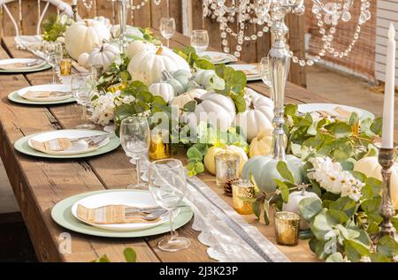 Decorazione autunnale e del giorno del Ringraziamento con mini zucche bianche. Riservato Thanksgiving o Halloween luogo impostazione in un casale tavolo set con mini Foto Stock